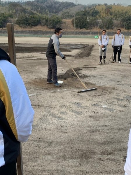 トンボを使ったグラウンド整備について野球部員に教える阪神園芸さんの様子